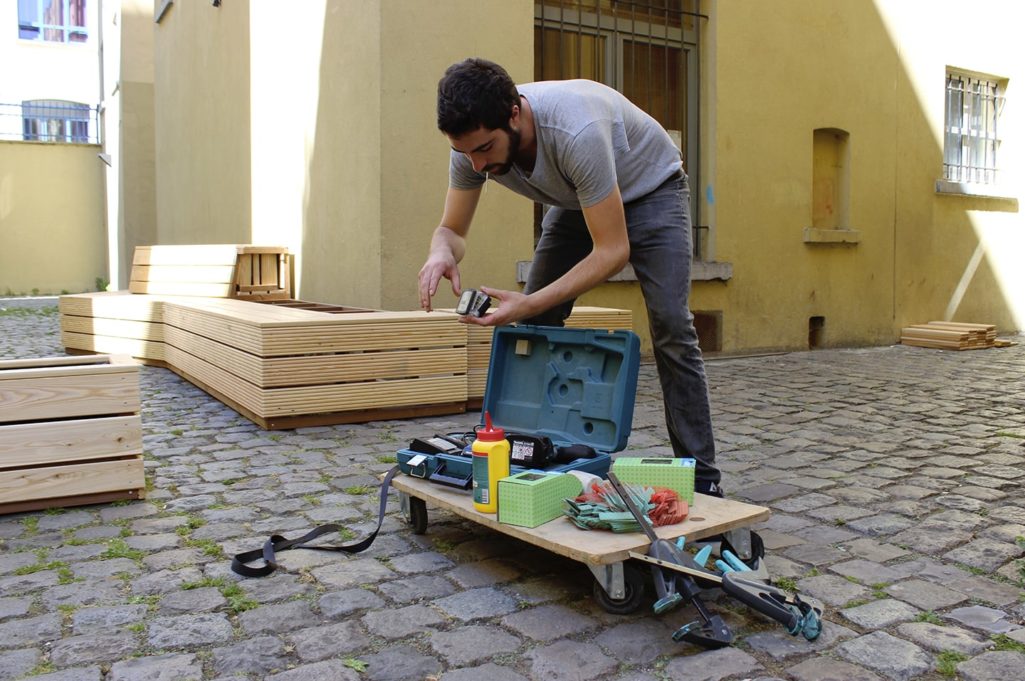 artisan avec ses outils installe un mobilier