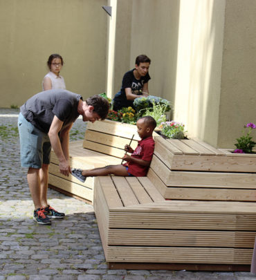 L'animateur refait le lacet de l'enfant assis